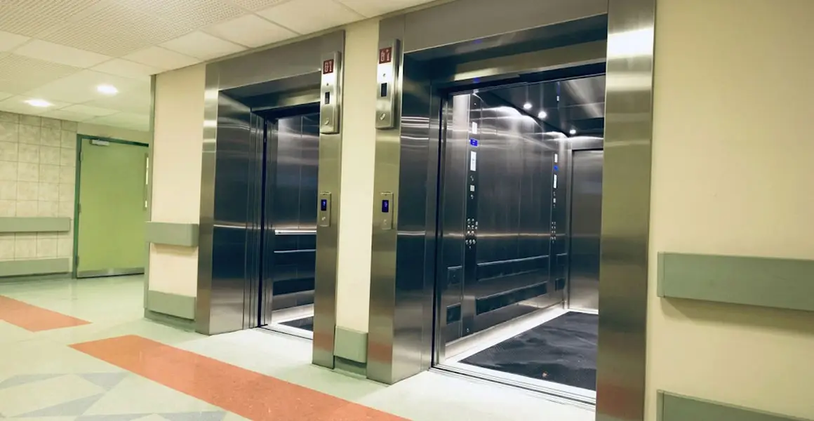 Modern stainless steel elevators installed in a commercial building hallway in Riyadh for professional elevator installation services.