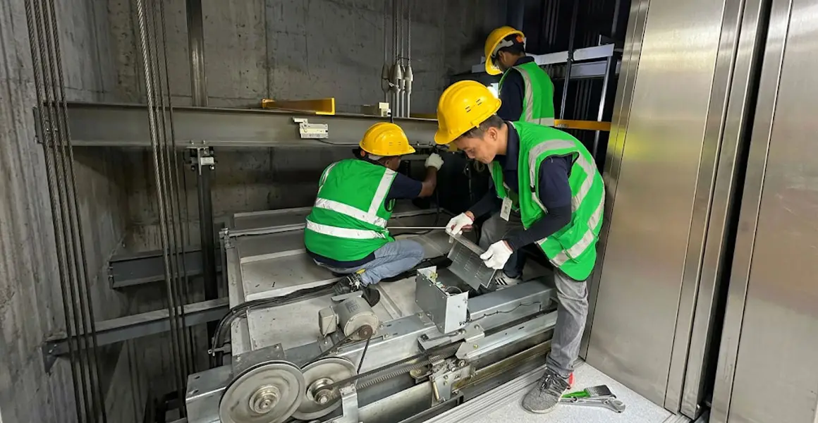 Professional team performing elevator maintenance and repair work in a building shaft in Riyadh.