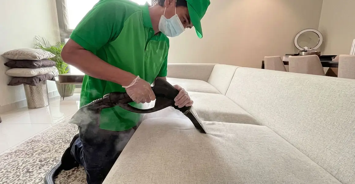Expert deep cleaning of sofa with steam extraction equipment by trained staff in Riyadh.